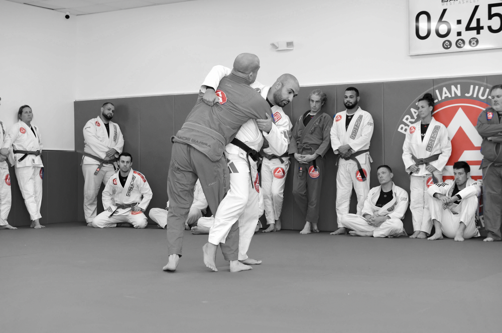Adults practicing a Jiu-Jitsu technique at the school